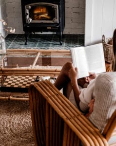 Reading A Book In Front Of A Lit Fireplace