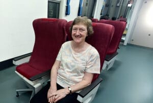 Smiling woman sitting on red train seat during a journey
