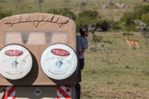 Safari vehicle from Gamewatchers Safaris with tourists observing antelope in African savannah