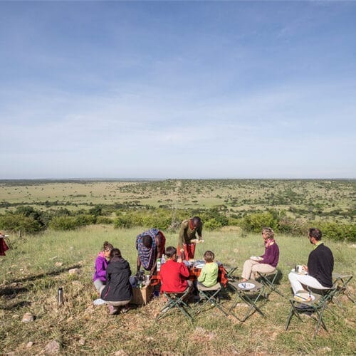Bush breakfast with guests overlooking Maasai Mara savannah