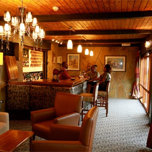 Guests enjoying drinks at safari lodge bar in Kenya