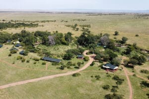 Aerial view of safari camp lodges surrounded by trees in the Maasai Mara, Kenya