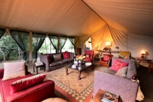 Luxury safari tent lounge with comfortable sofas and traditional decor in Maasai Mara Kenya