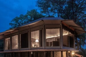 Luxury safari tent accommodation illuminated at night in the African wilderness