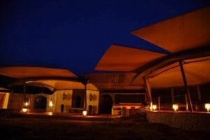 Luxury safari lodge at night with lantern lighting and starlit sky in Kenya