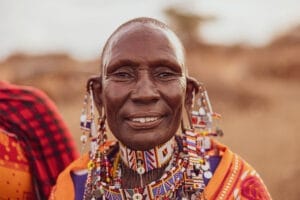 Elderly Maasai woman wearing traditional colorful beadwork jewelry and clothing in Kenya