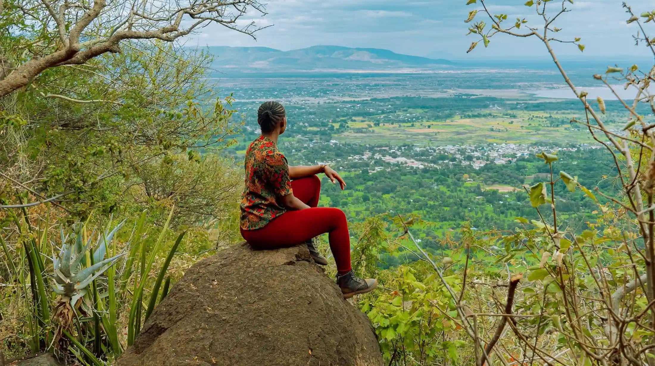Lady on a rock admiring the view from Kirurumu Manyara Tented Camp.
