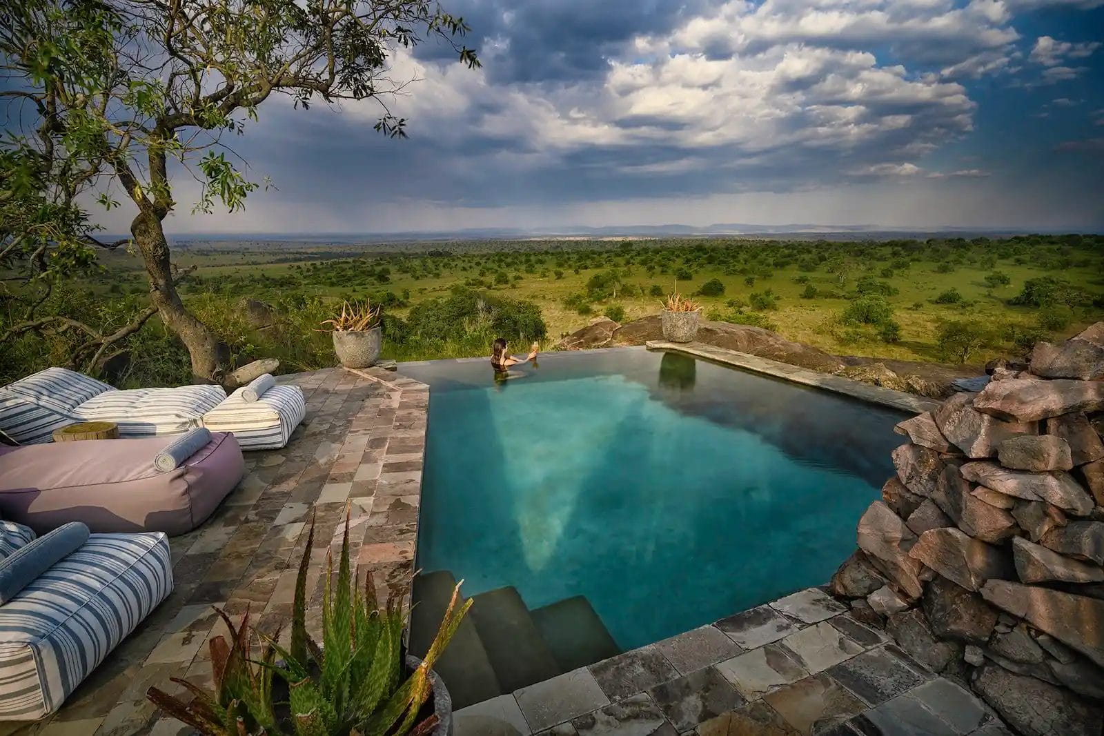 Guest in the pool with stunning views at Nimali Mara Camp in the Serengeti Tanzania