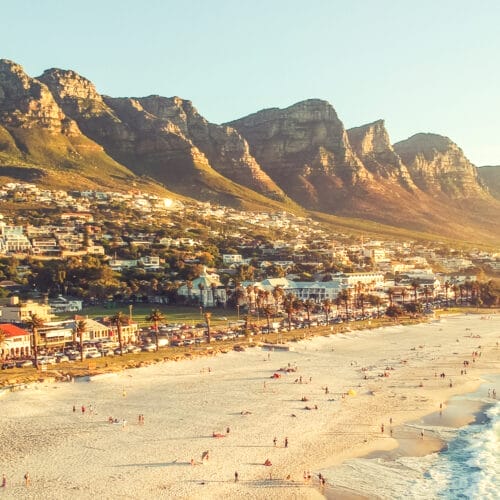 Stunning wide angle aerial drone evening view of Camps Bay, an affluent suburb of Cape Town, Western Cape, South Africa. Twelve apostles mountain range in the background. Photo cross processed.