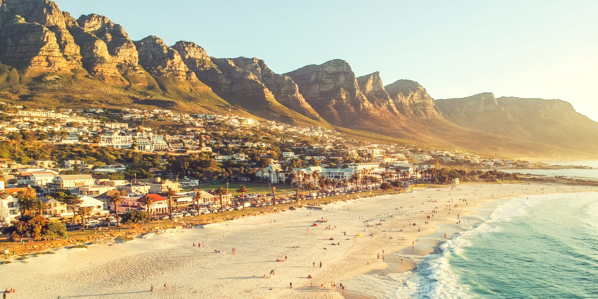 Stunning wide angle aerial drone evening view of Camps Bay, an affluent suburb of Cape Town, Western Cape, South Africa. Twelve apostles mountain range in the background. Photo cross processed.