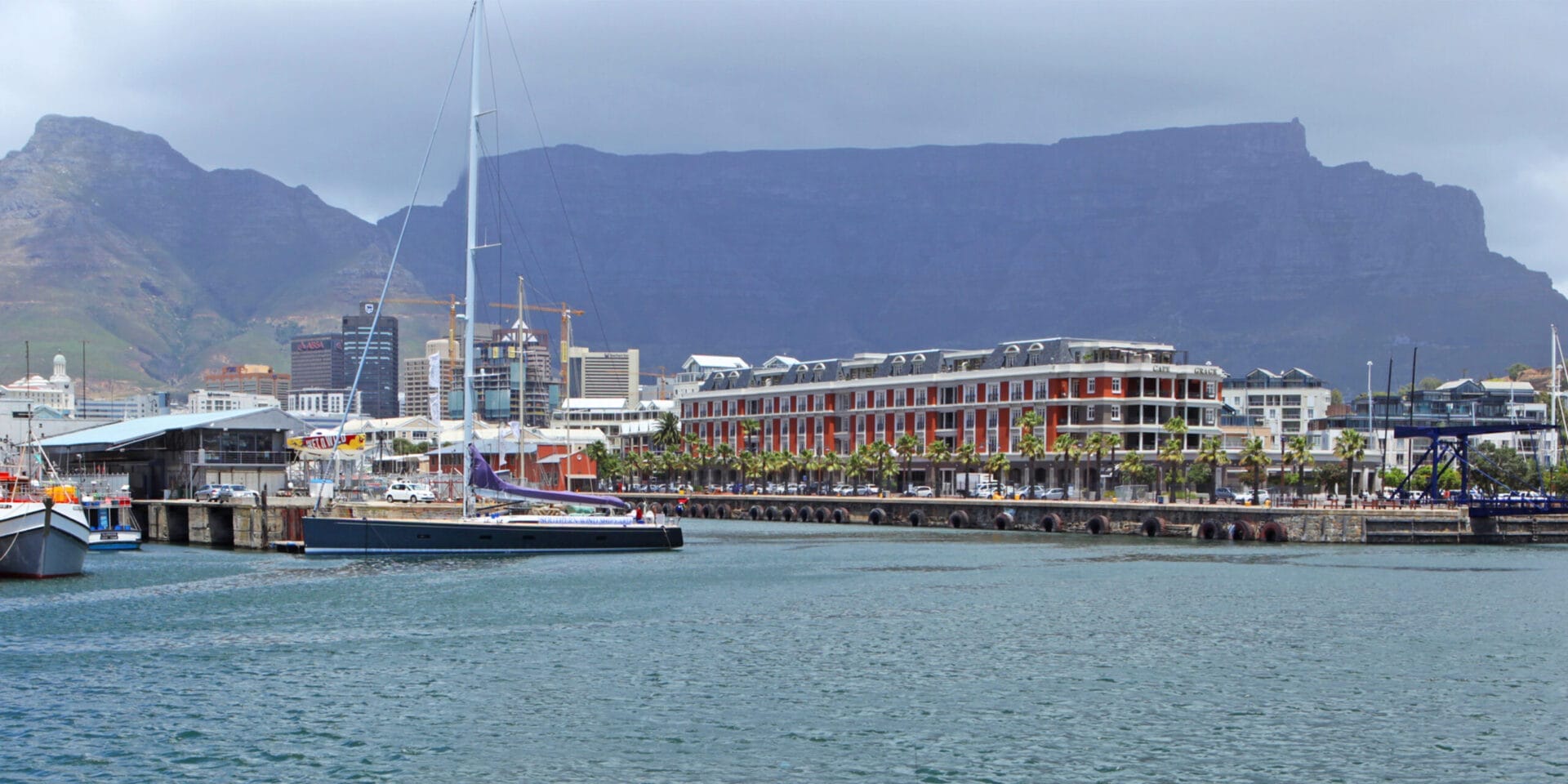 Cape Town Harbour at Victoria and Alfred Waterfront. with boats, downtown buildings and the famous Table Mountain.