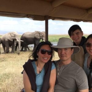 Family photo on a safari with elephants in the background during an African wildlife tour