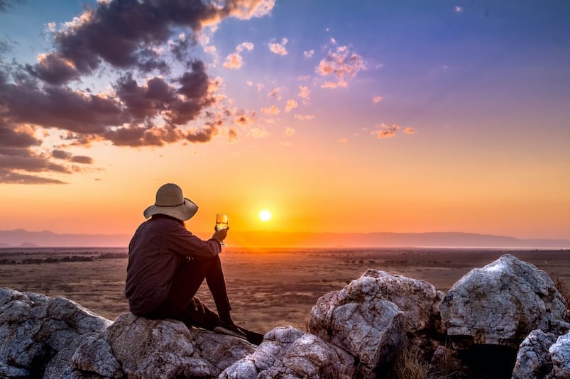 Guest on rock enjoying the sunset at Nimali Tarangire in Tanzania