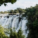 tropical-waterfall-landscape | Gamewatchers Safaris Waterfall surrounded by lush greenery