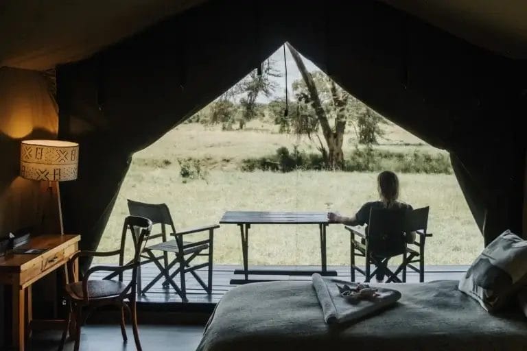 Guest sitting on veranda in front of Porini Rhino Camp in Ol Pejeta Conservancy. Photo credit Misha Martin