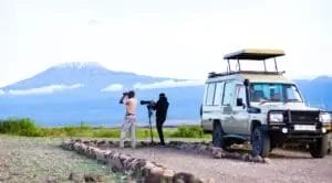Guide and guest view birds in front of Kilimanjaro from Amboseli Serena Lodge Kenya.