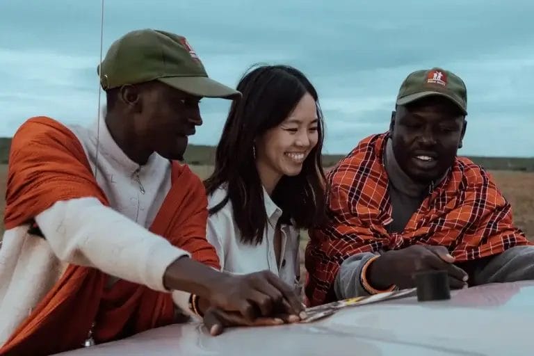Professional Maasai Guides look over map with lady guest taken from Porini Safari Cottages in Ol Kinyei Conservancy in Kenya. Photo credit Celine & Sacha