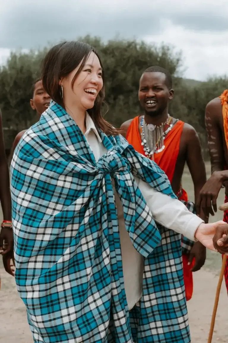 Lady smiling wearing a Maasai shuka at Porini Safari Cottages. Photo credit Celine & Sacha