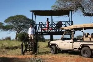 Safari Guide & guest standing on the viewpoint with a safari vehicle in Selenkay Conservancy in Kenya..Photo credit Rameez and Nabel