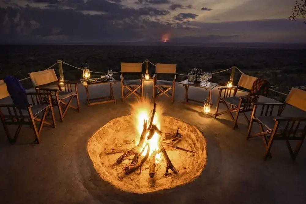 Terrace at night with fire pit and chairs at Ilaroi in Tanzania