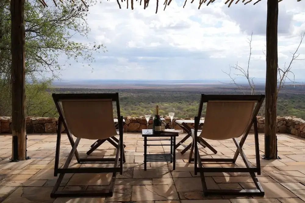 Terrace with two chairs and wine overlooking beautiful view at Ilaroi in Tanzania