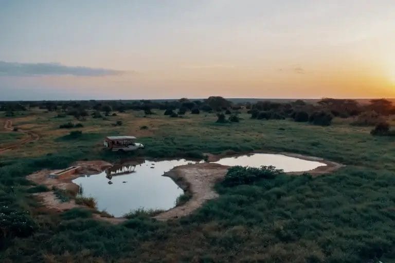 Selenkay Water hole and safari vehicle.